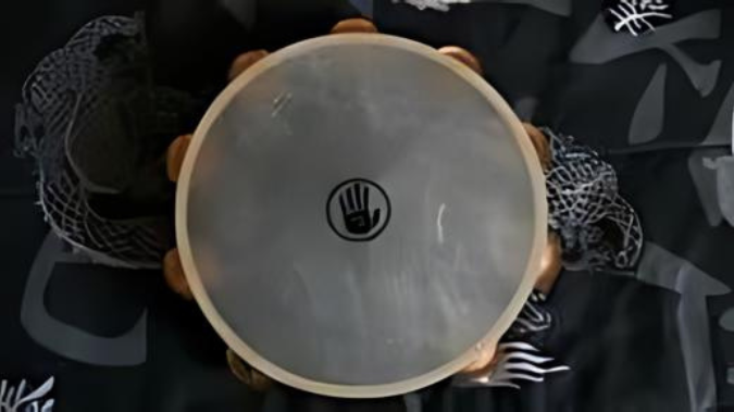 A wooden drum, resembling a tambourine, with a dragon design on it.