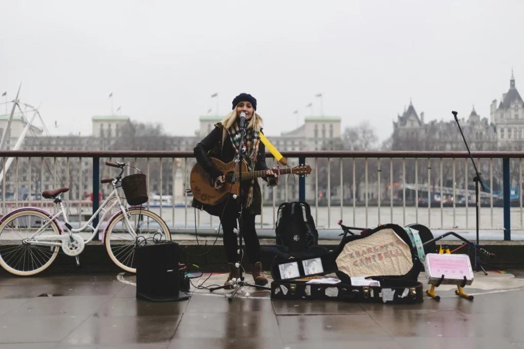 a woman playing guitar and singing on a bridge